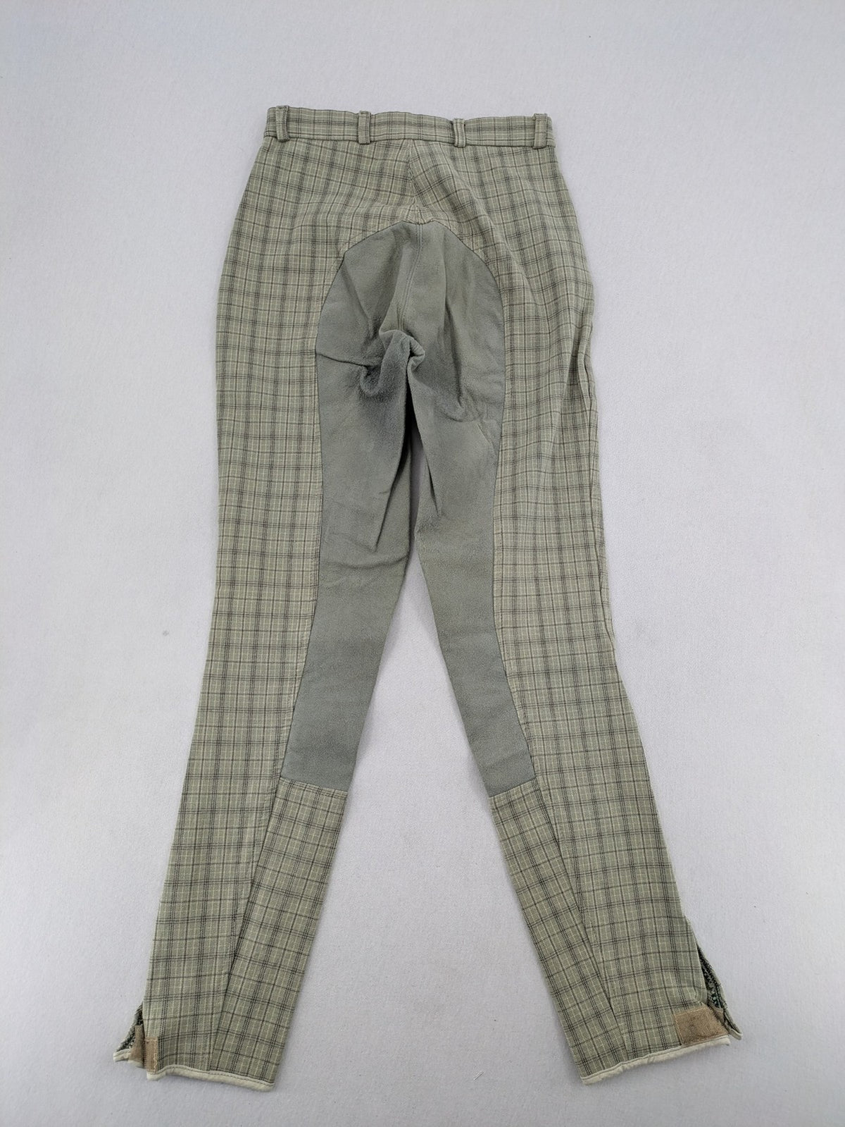 Jodhpur beige and grey riding pants with green check pattern and knee patches.