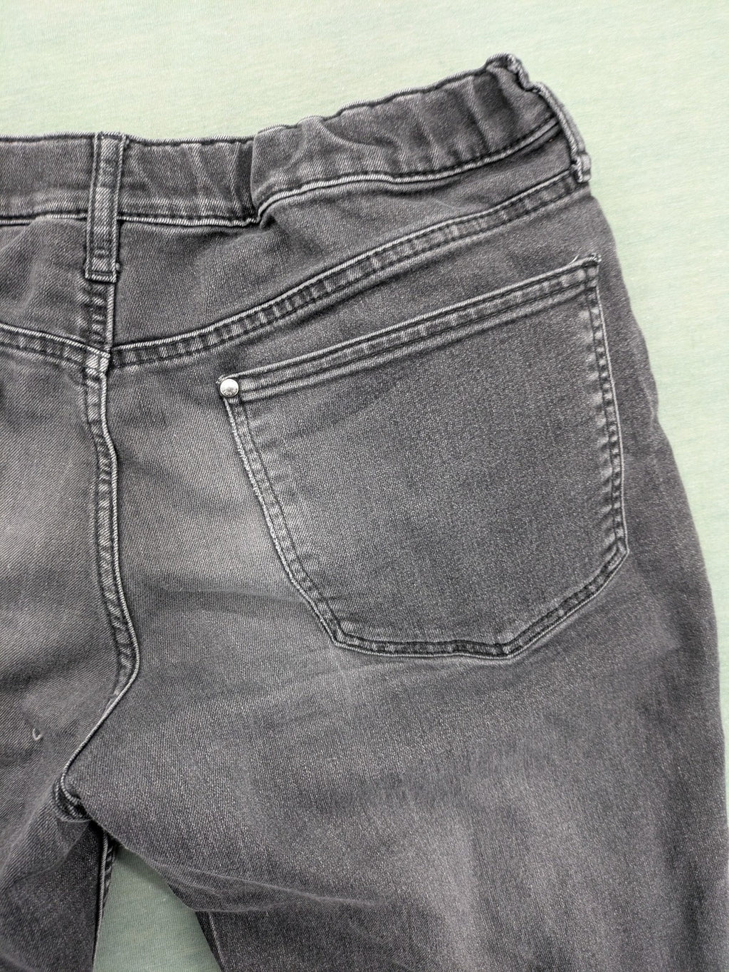 H&M grey slim fit jeans with adjustable waistband and faded wash detail.