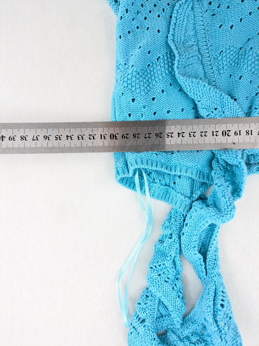 Springfield blue knit top with ruffled straps, peplum hem, and lace embroidery.