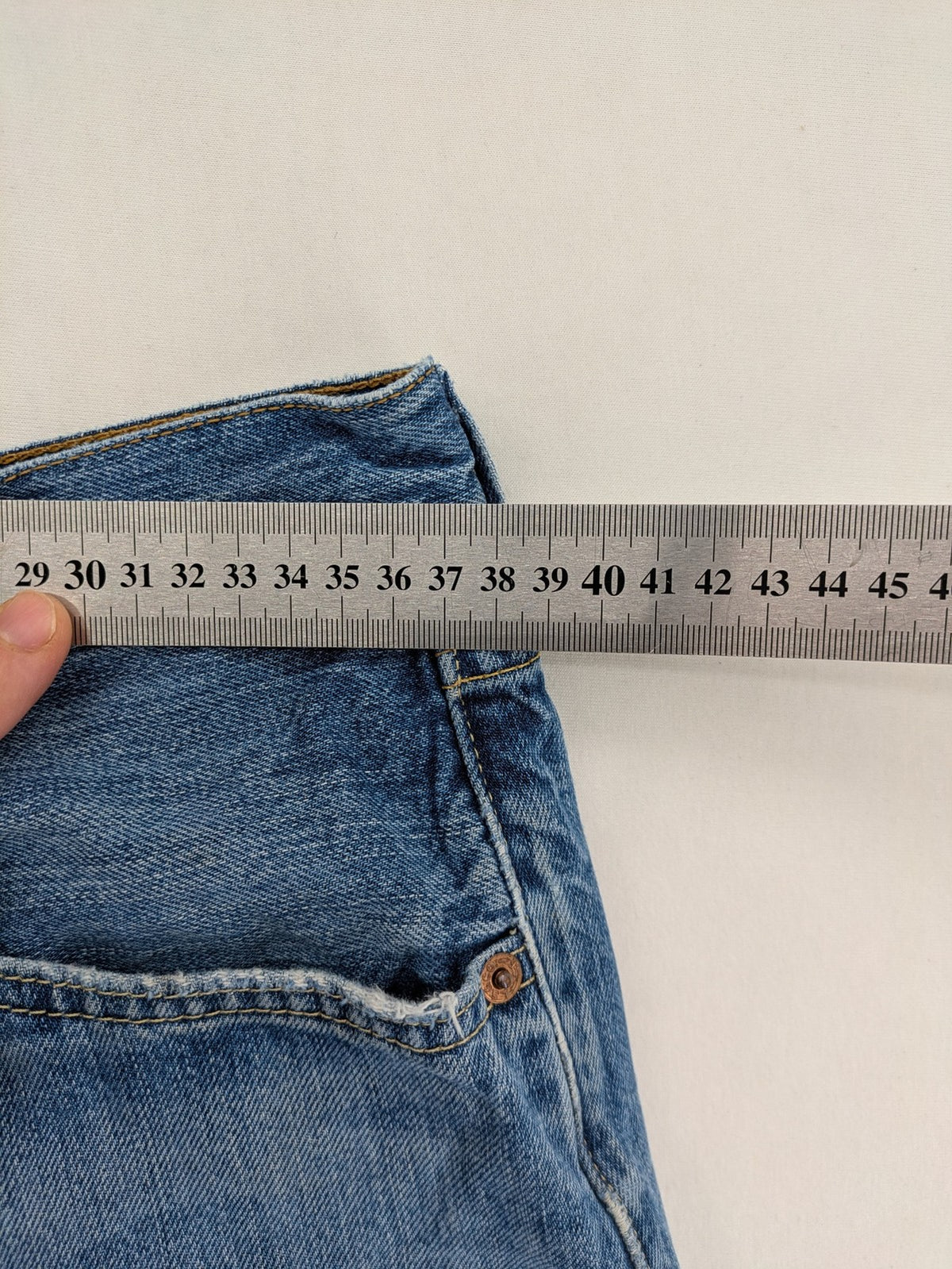 Levi's blue straight jeans with button-fly and distressed knee rips.