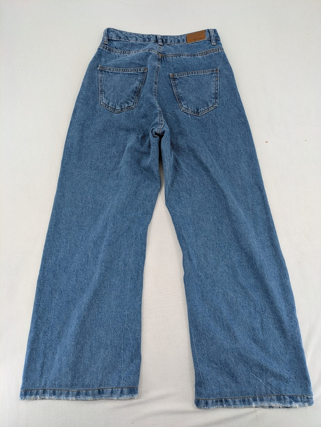 X.LOVE blue high waist wide leg jeans with front pleats and frayed hem.