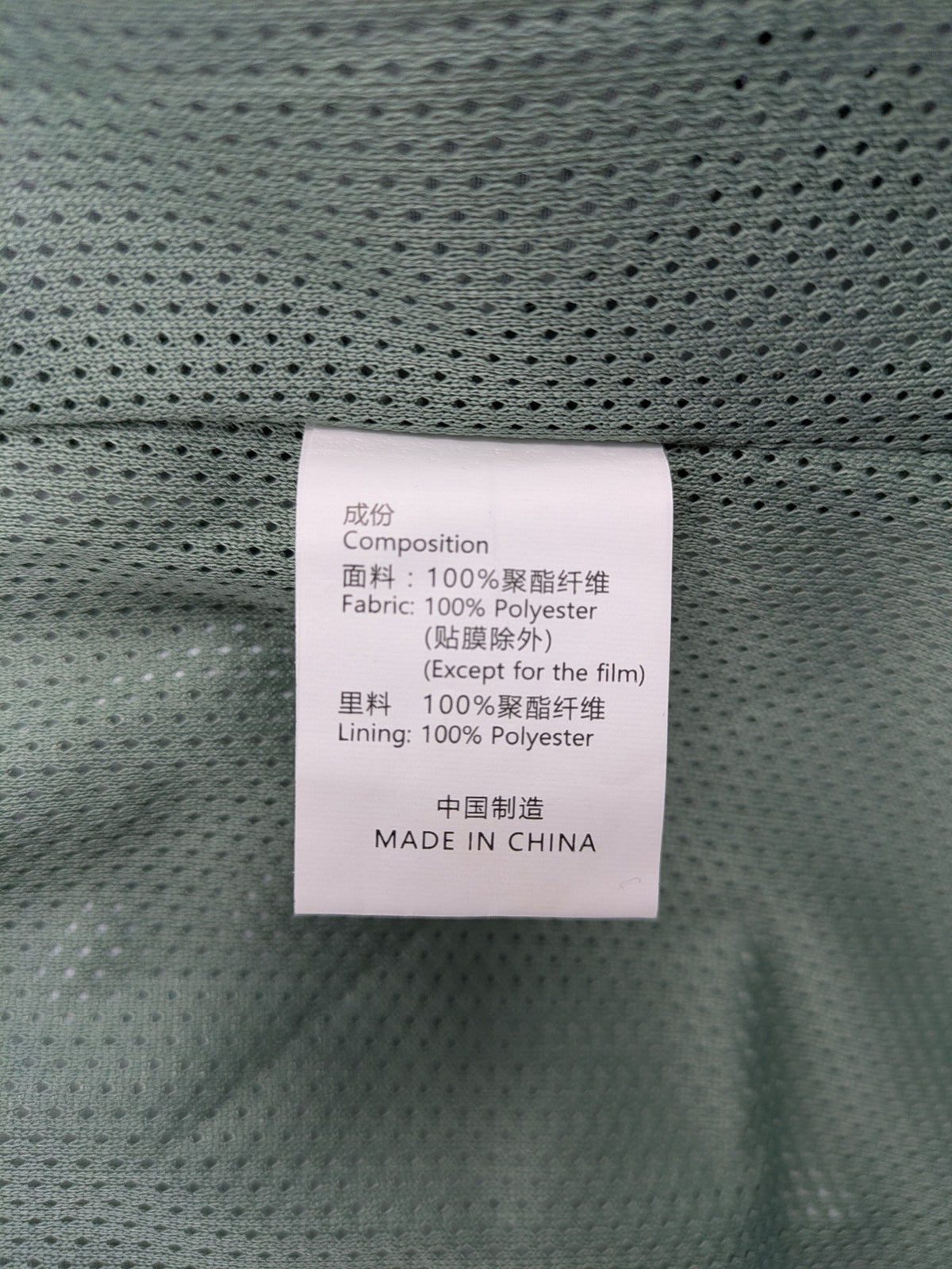 Outdoor green jacket with allover leaf print, adjustable hood, and front zipper.
