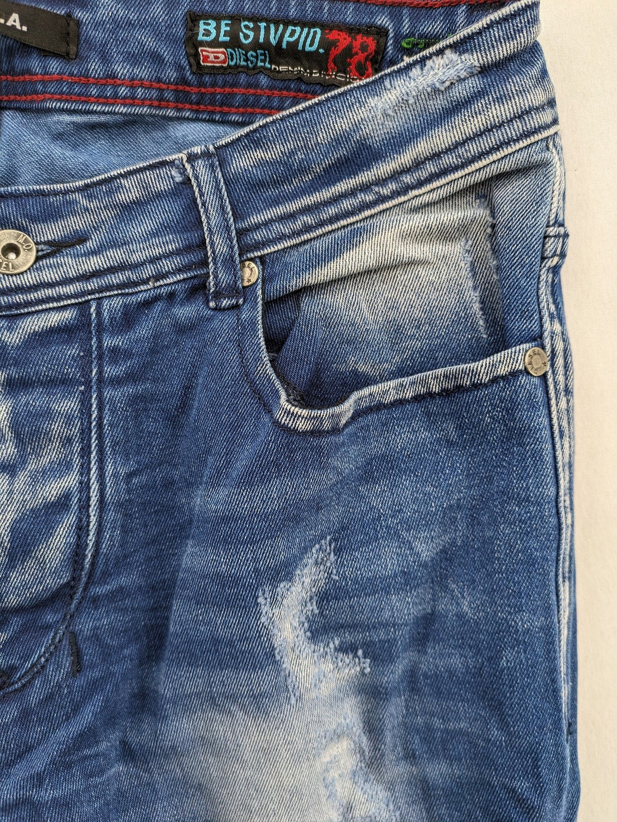 Diesel blue straight jeans with distressed details and ripped accents, made of cotton.