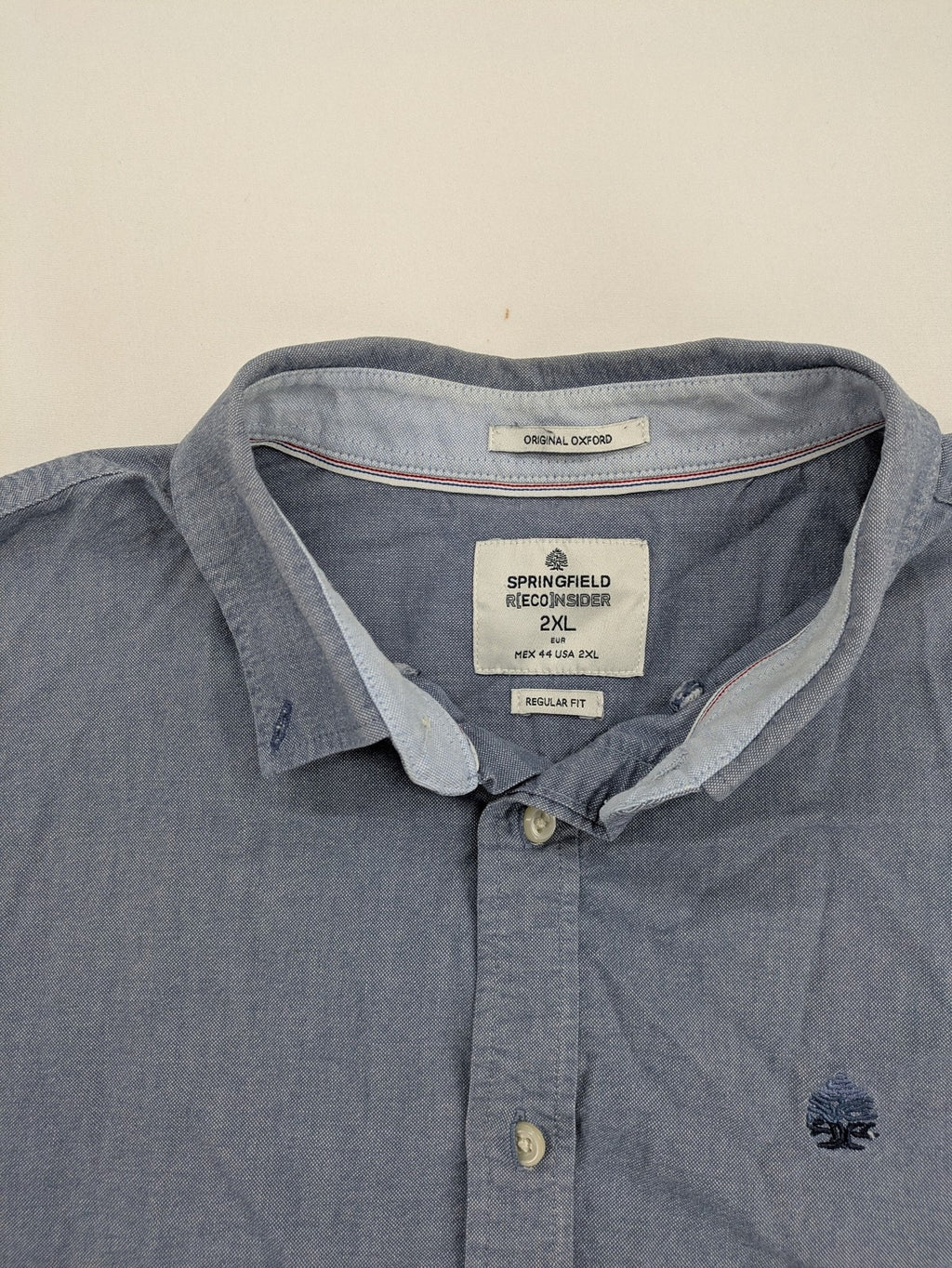 Springfield blue Oxford shirt with button placket and subtle logo embroidery.