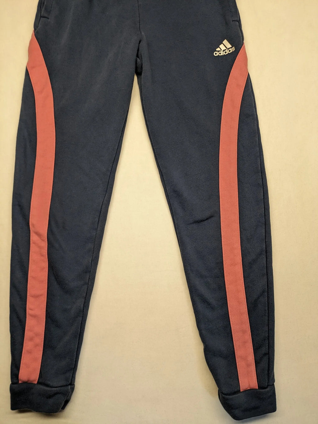 Adidas grey joggers with pink stripes and iconic logo on thigh.