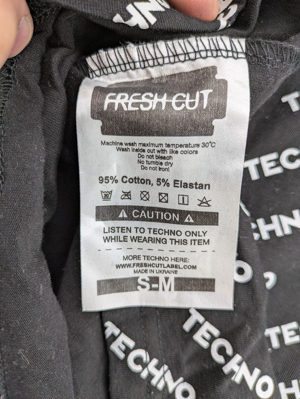 Fresh Cut black techno t-shirt all-over print with bold "TECHNO" graphic design.