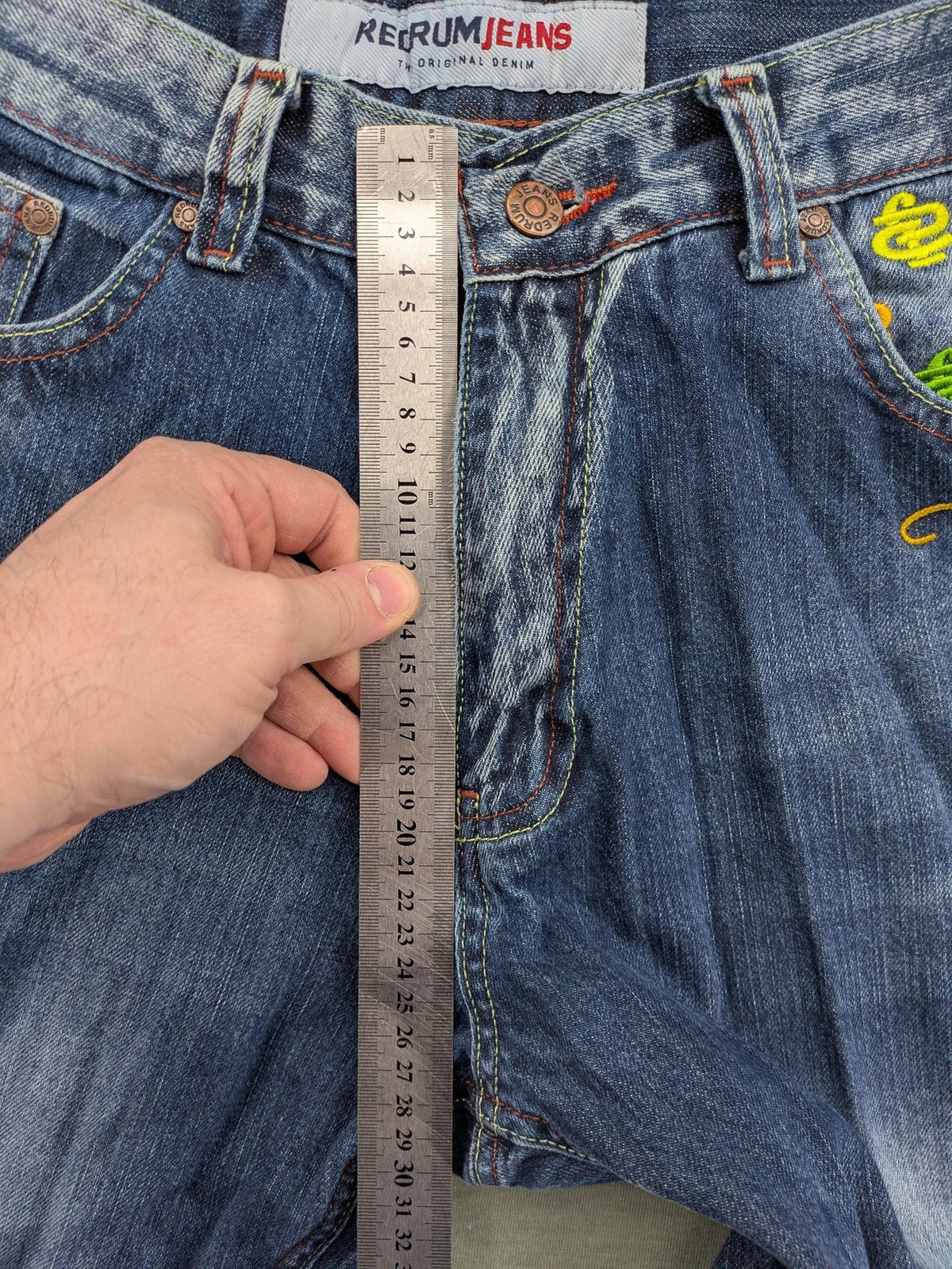 Y2K blue straight jeans with colorful logo embroidery and baggy fit.