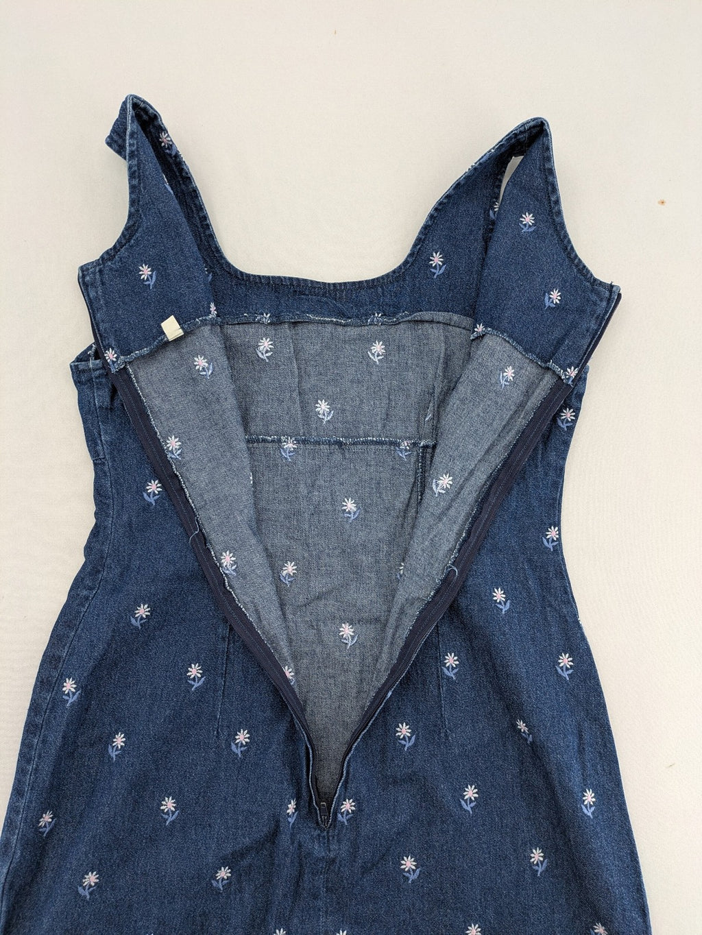 Damen blue denim mini dress with all-over white and light blue floral embroidery.