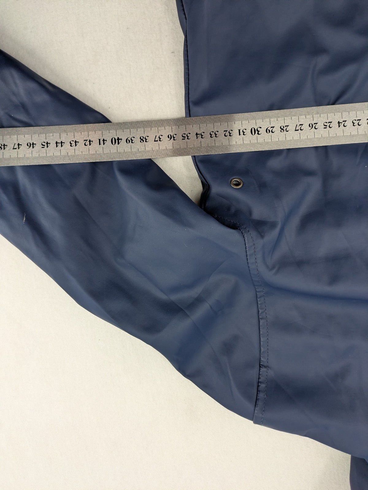 Pocopiano navy raincoat with striped lining and waterproof exterior, classic fisherman style.