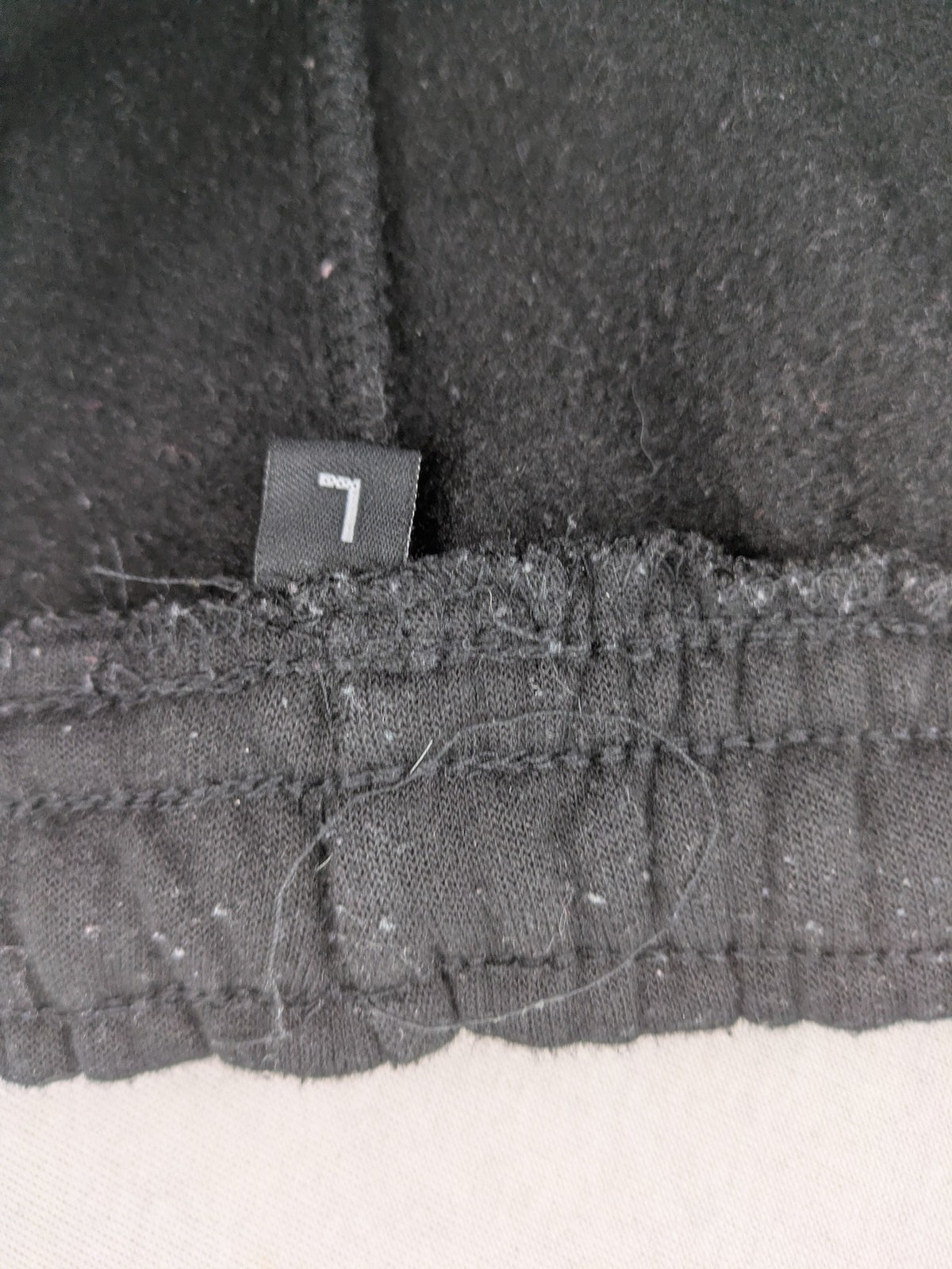 Kuyruun black jogging pants with kangaroo logo, elastic waistband, and ribbed cuffs.