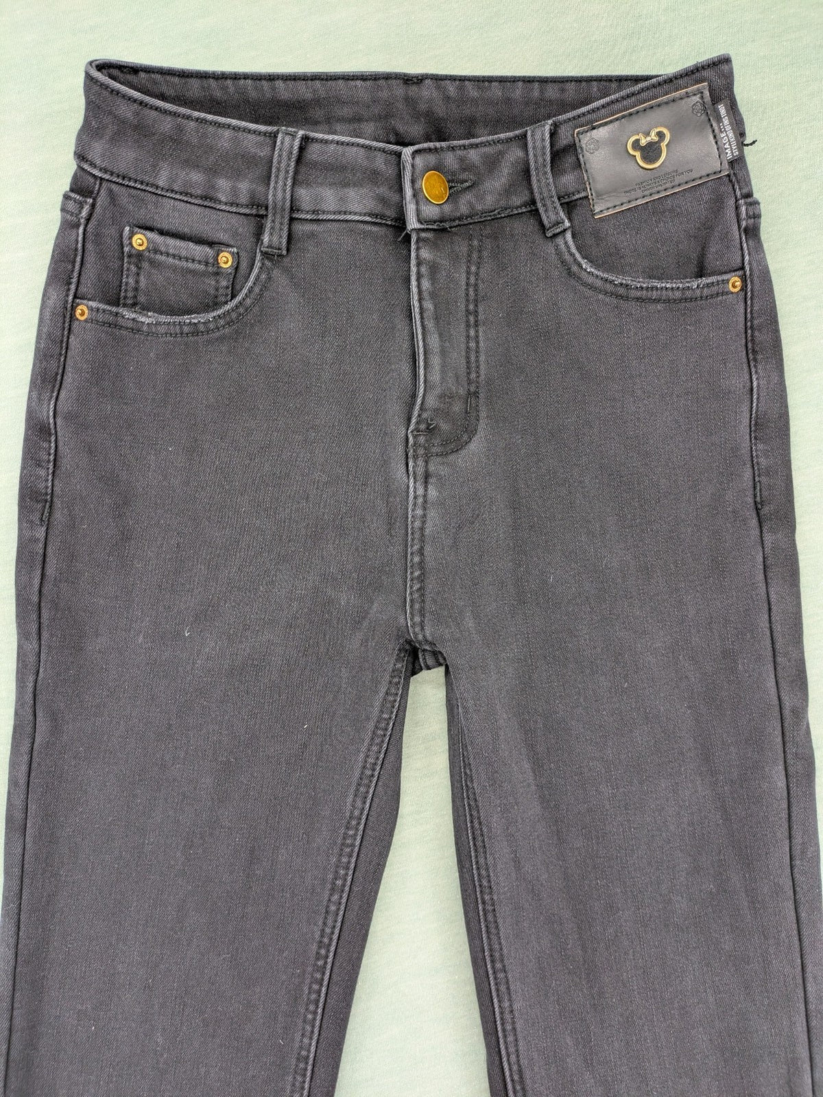 Disney black straight jeans with Minnie Mouse detail, cropped length, stretchy cotton blend.