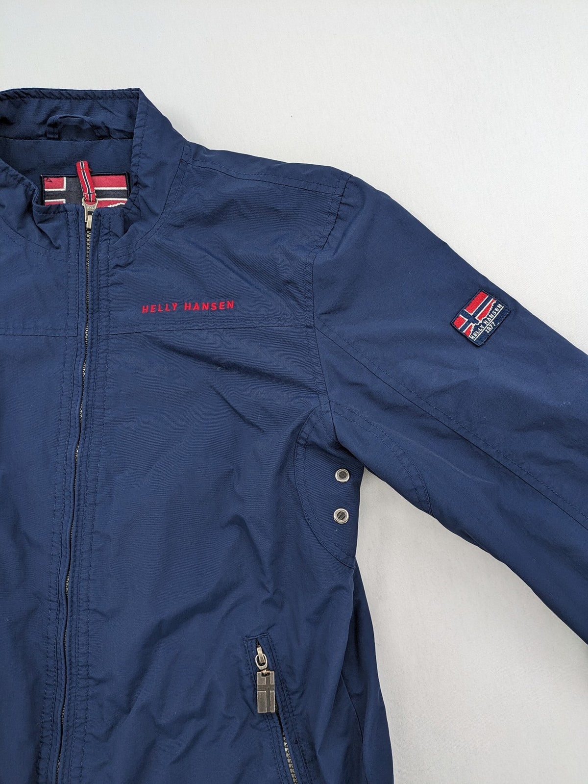 Helly Hansen navy jacket with red accents and logo, full zip, breathable mesh lining.
