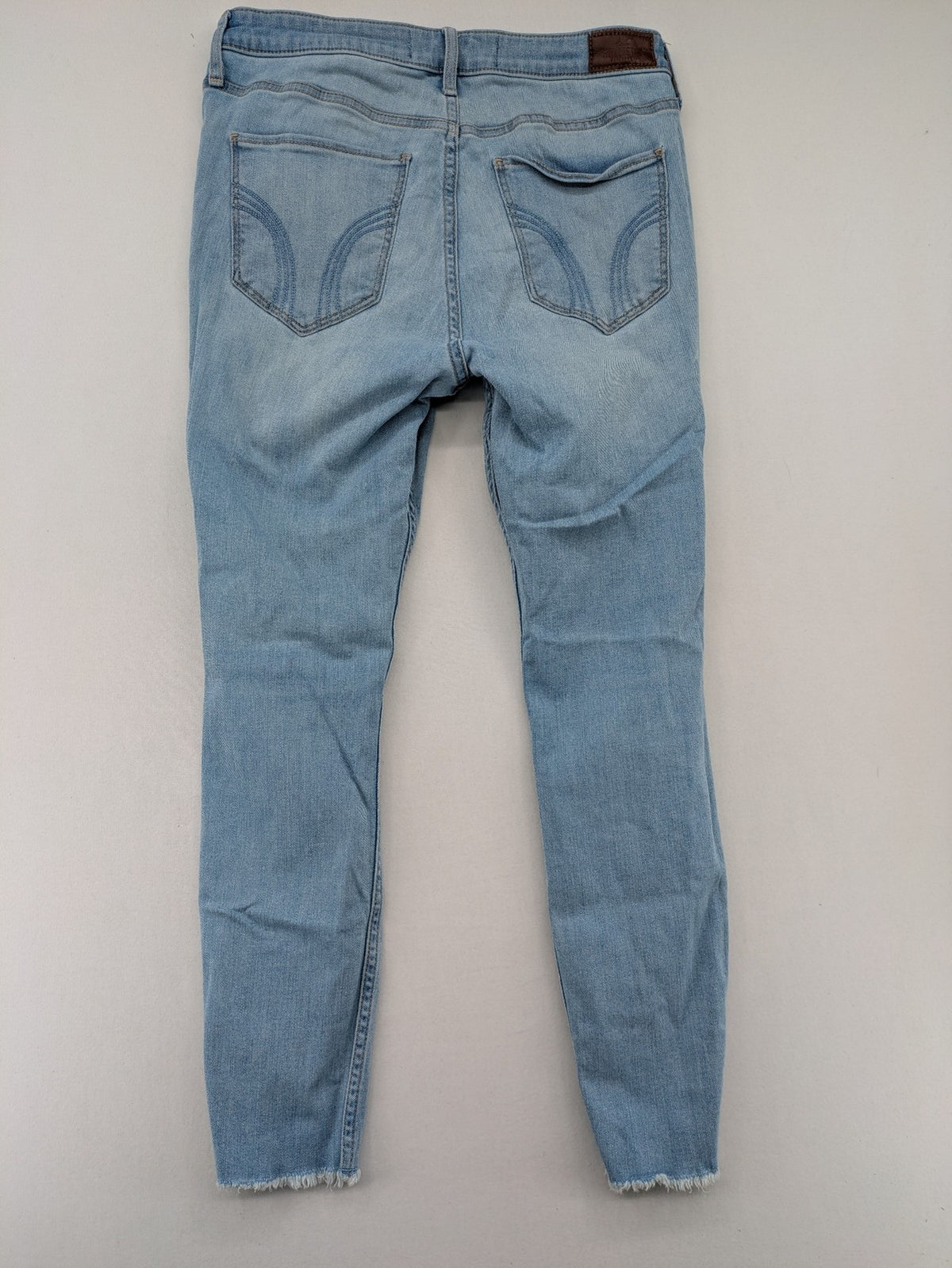 Hollister blue high-rise crop super skinny jeans with distressed rips and frayed hem.