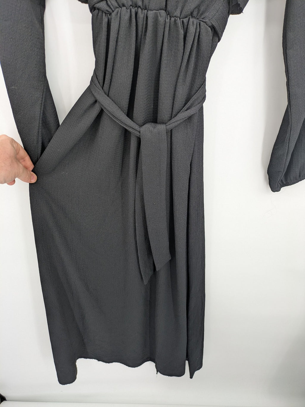 Hakke black maxi dress with ruffle details, long sleeves, and matching belt.