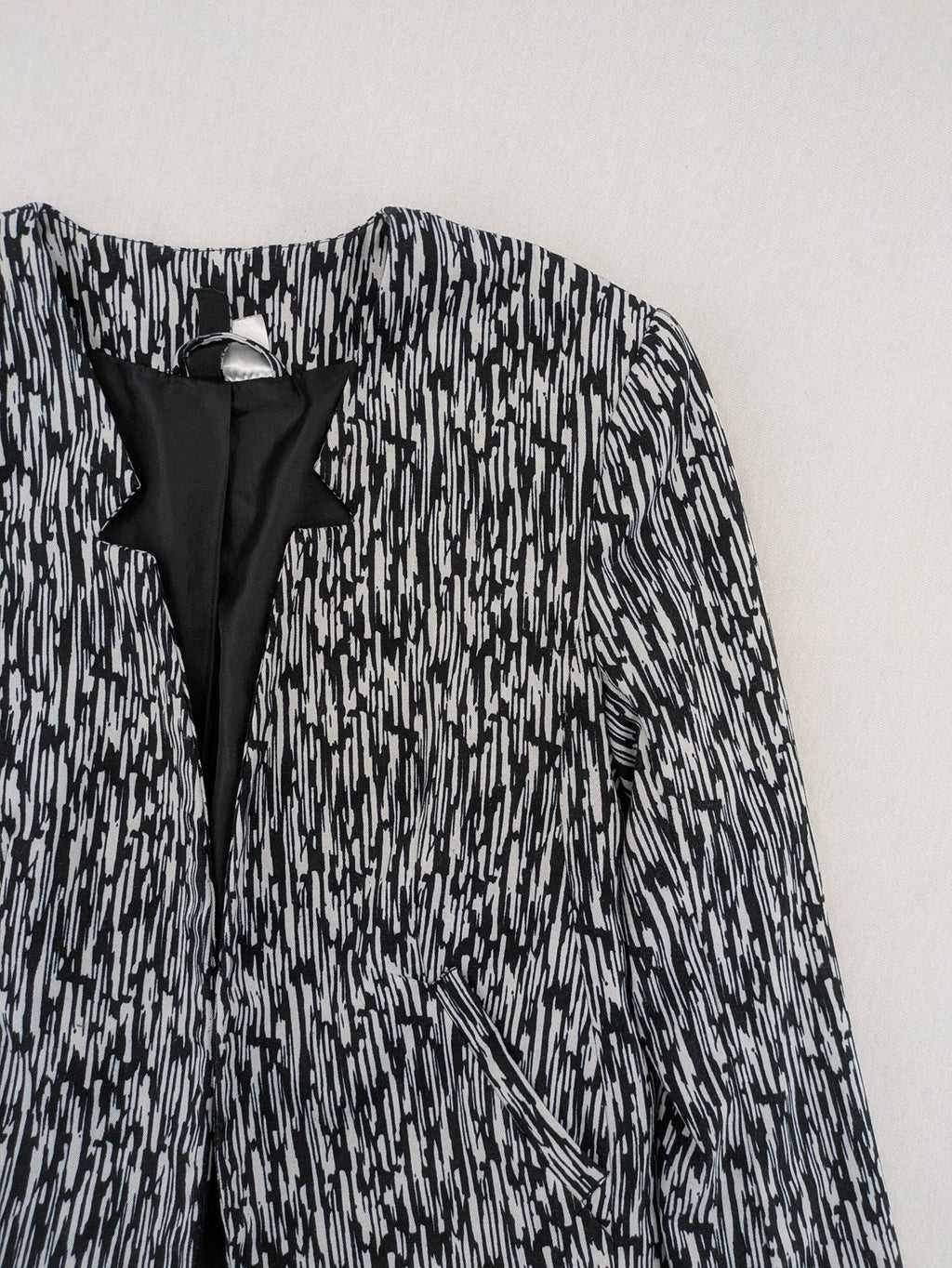 H&M Divided black and white patterned blazer with open front and two front pockets.