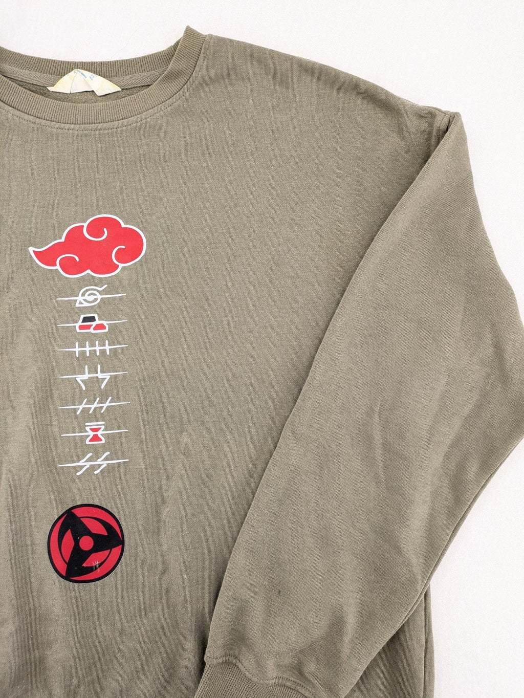 Naruto khaki turtle neck jumper featuring red Akatsuki cloud and Sharingan symbols.
