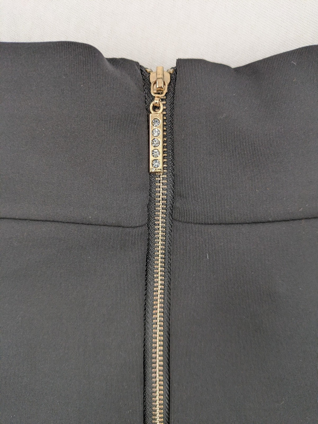 Romatie black mini bodycon skirt satin finish high waist with gold zippers and buckles.