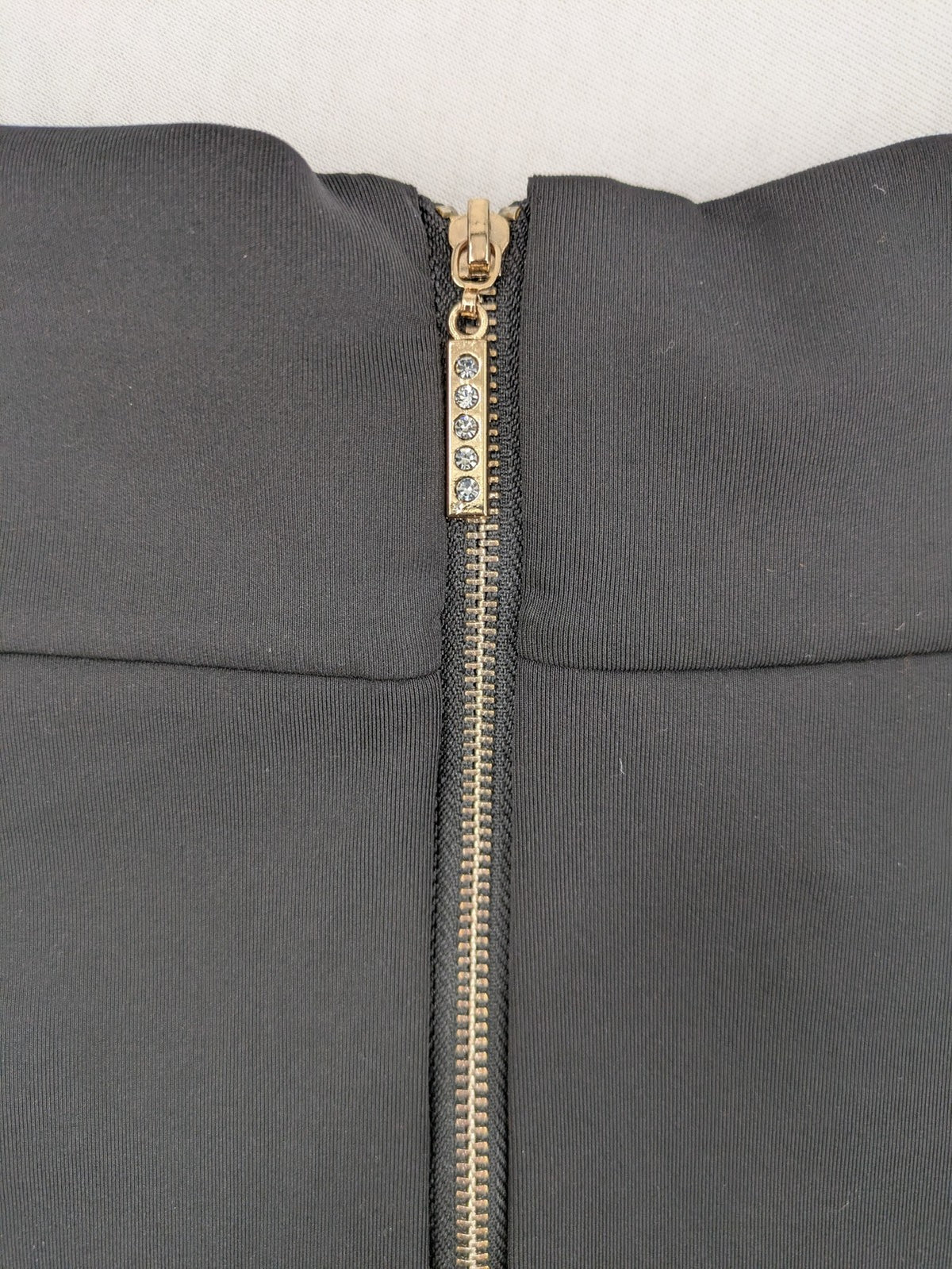 Romatie black mini bodycon skirt satin finish high waist with gold zippers and buckles.