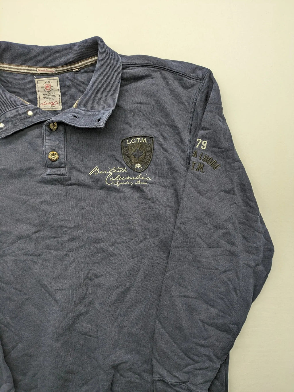 Lerros blue turtle neck jumper with stitched 'British Columbia' detail and button accents.