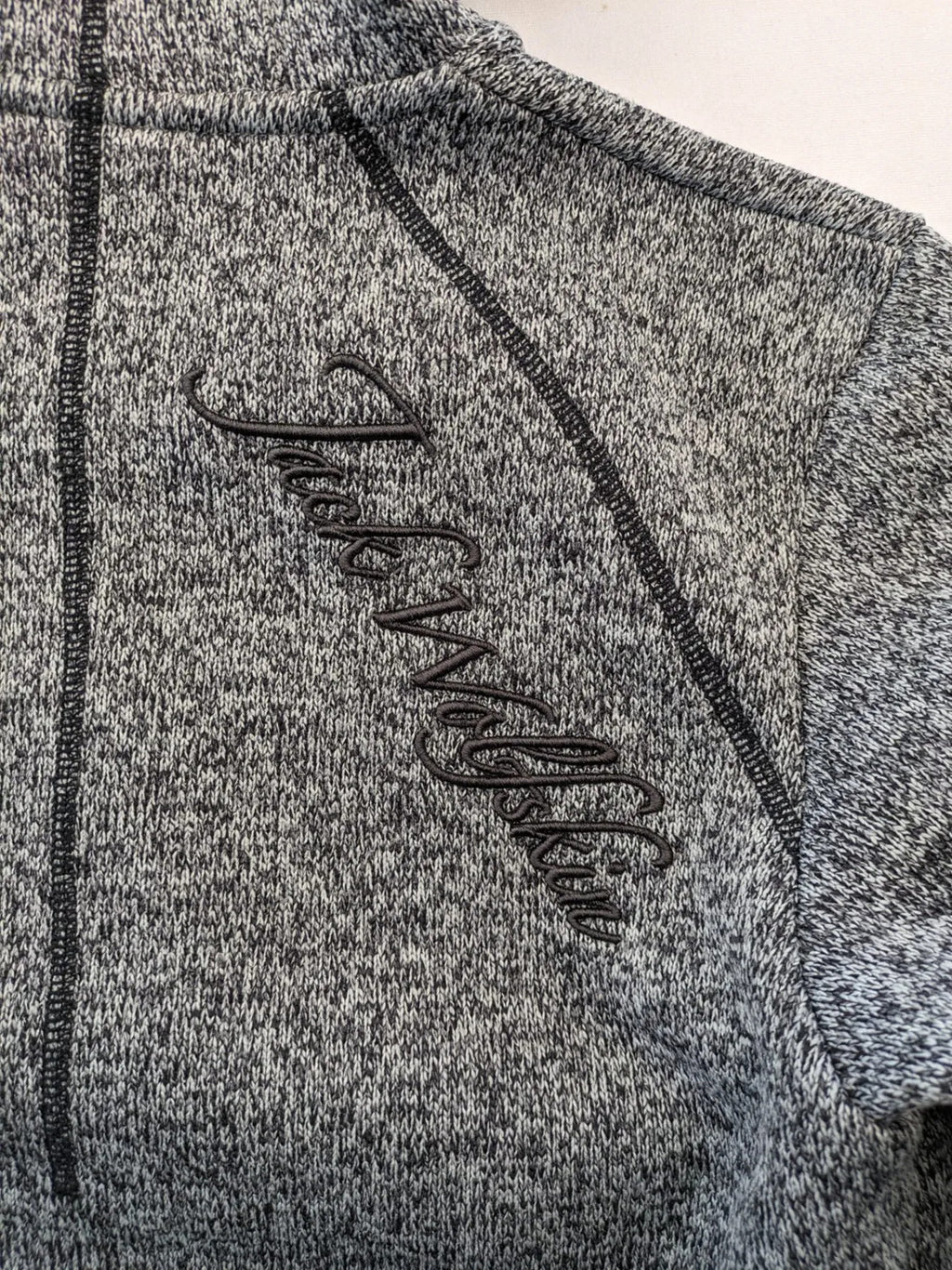 Jack Wolfskin grey fleece jacket with logo detailing and two front pockets.
