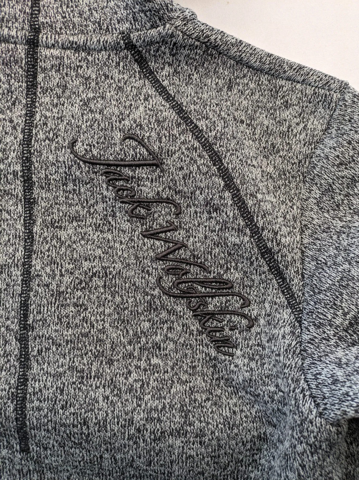 Jack Wolfskin grey fleece jacket with logo detailing and two front pockets.