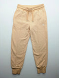 Hummel beige jogging pants with adjustable drawstring, embroidered logo, and ankle cuffs.