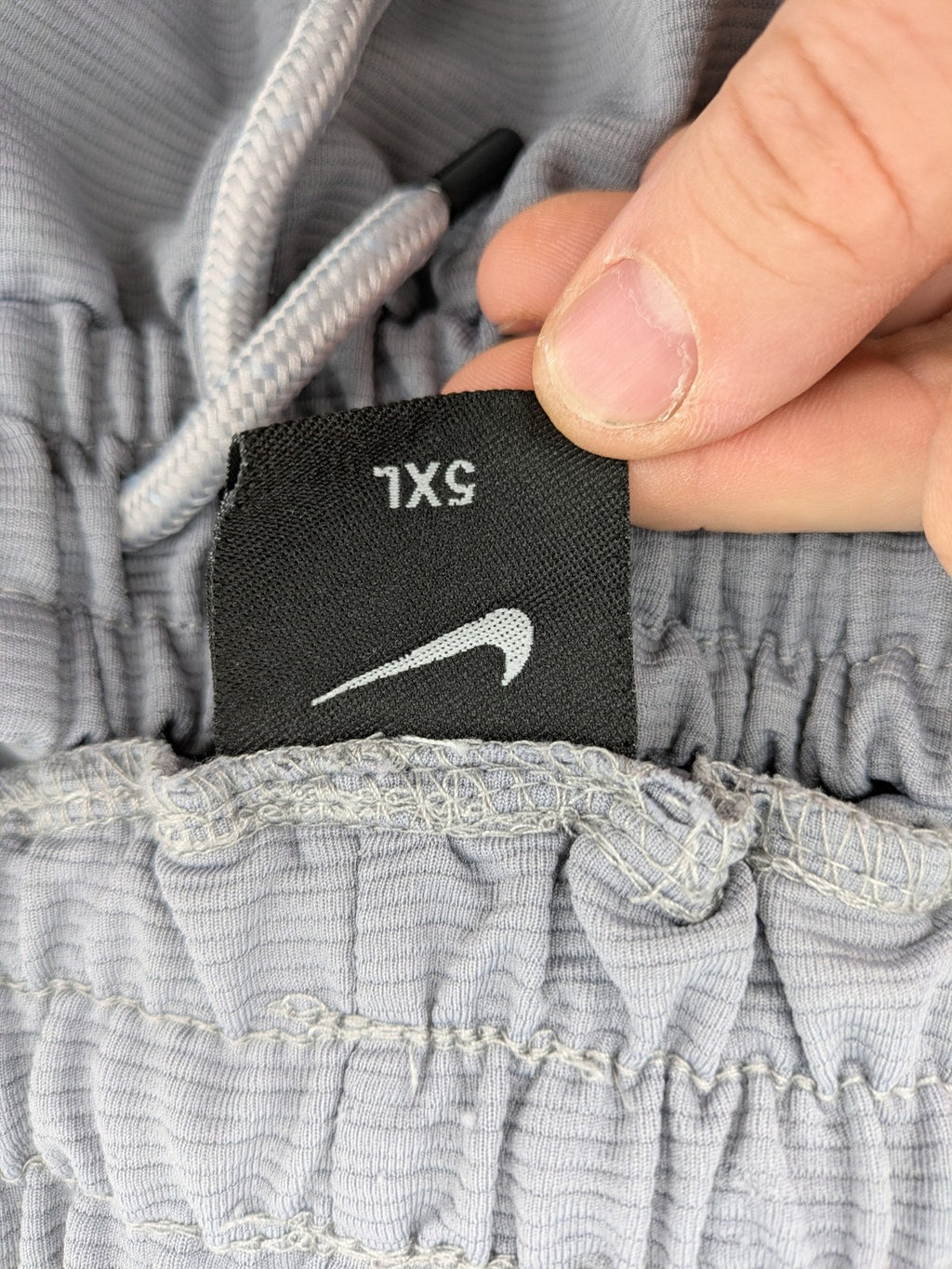 Nike grey shorts with Dri-FIT technology, elastic waistband, and zippered pockets.