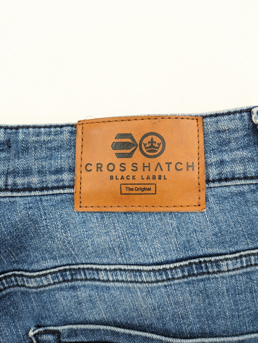 Crosshatch blue slim fit jeans with faded wash and logo patch on back pocket.