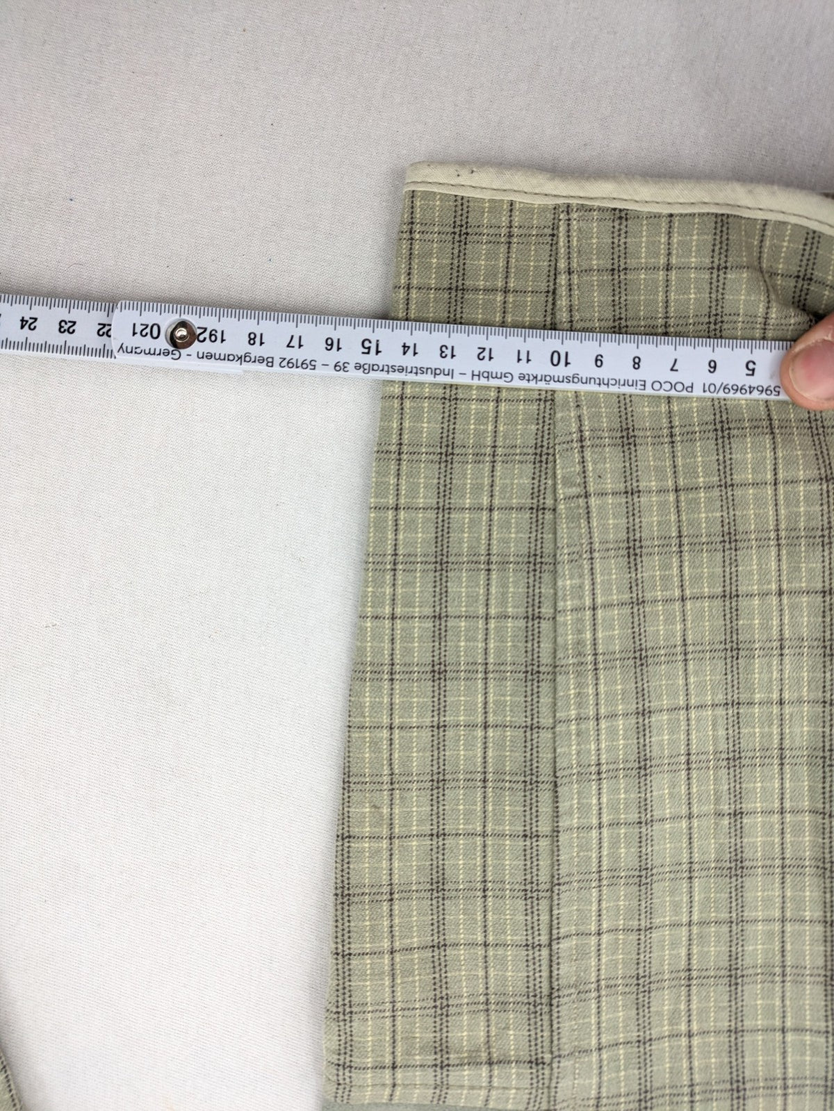 Jodhpur beige and grey riding pants with green check pattern and knee patches.