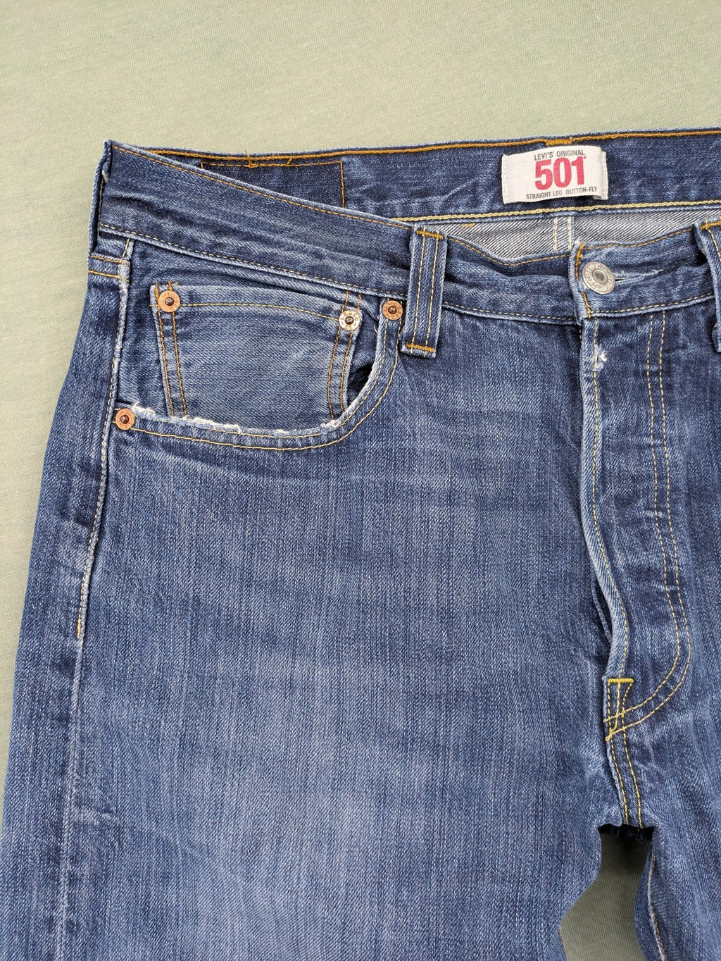 Levi's blue cut-off shorts with frayed hem, classic 5-pocket design, button fly.