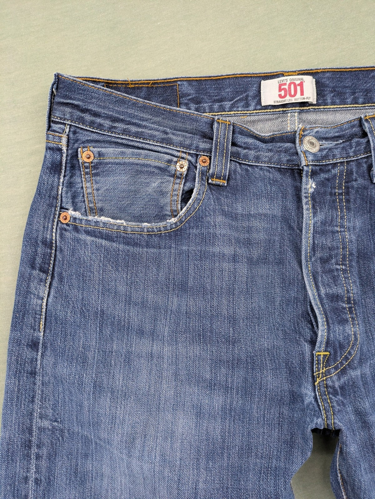 Levi's blue cut-off shorts with frayed hem, classic 5-pocket design, button fly.