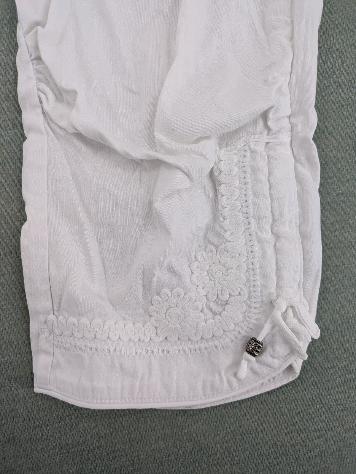 TREDY white capri pants with delicate floral embroidery and wide comfort waistband.