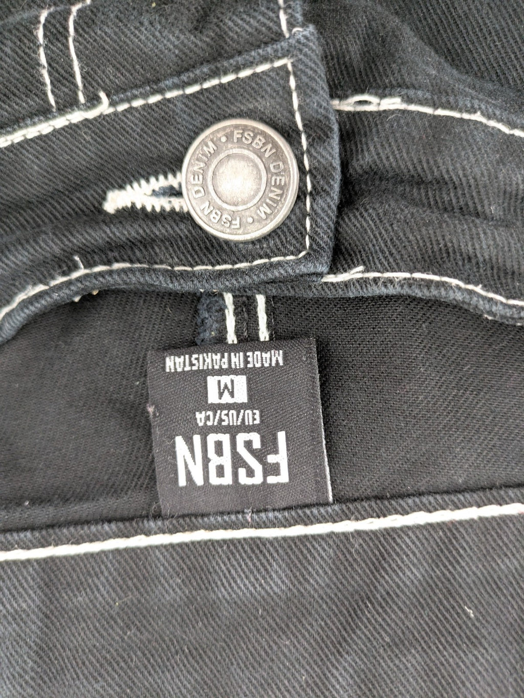 FSBN black baggy cargo pants with white contrast stitching and multiple pockets.