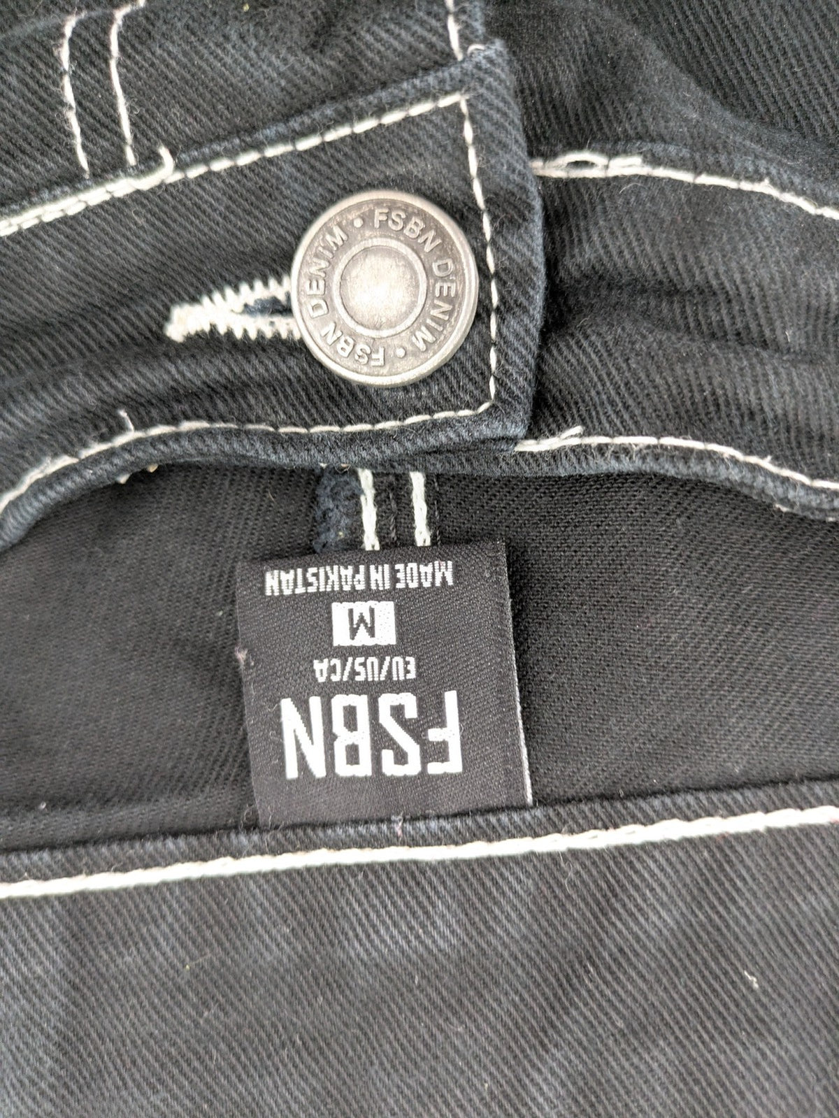 FSBN black baggy cargo pants with white contrast stitching and multiple pockets.