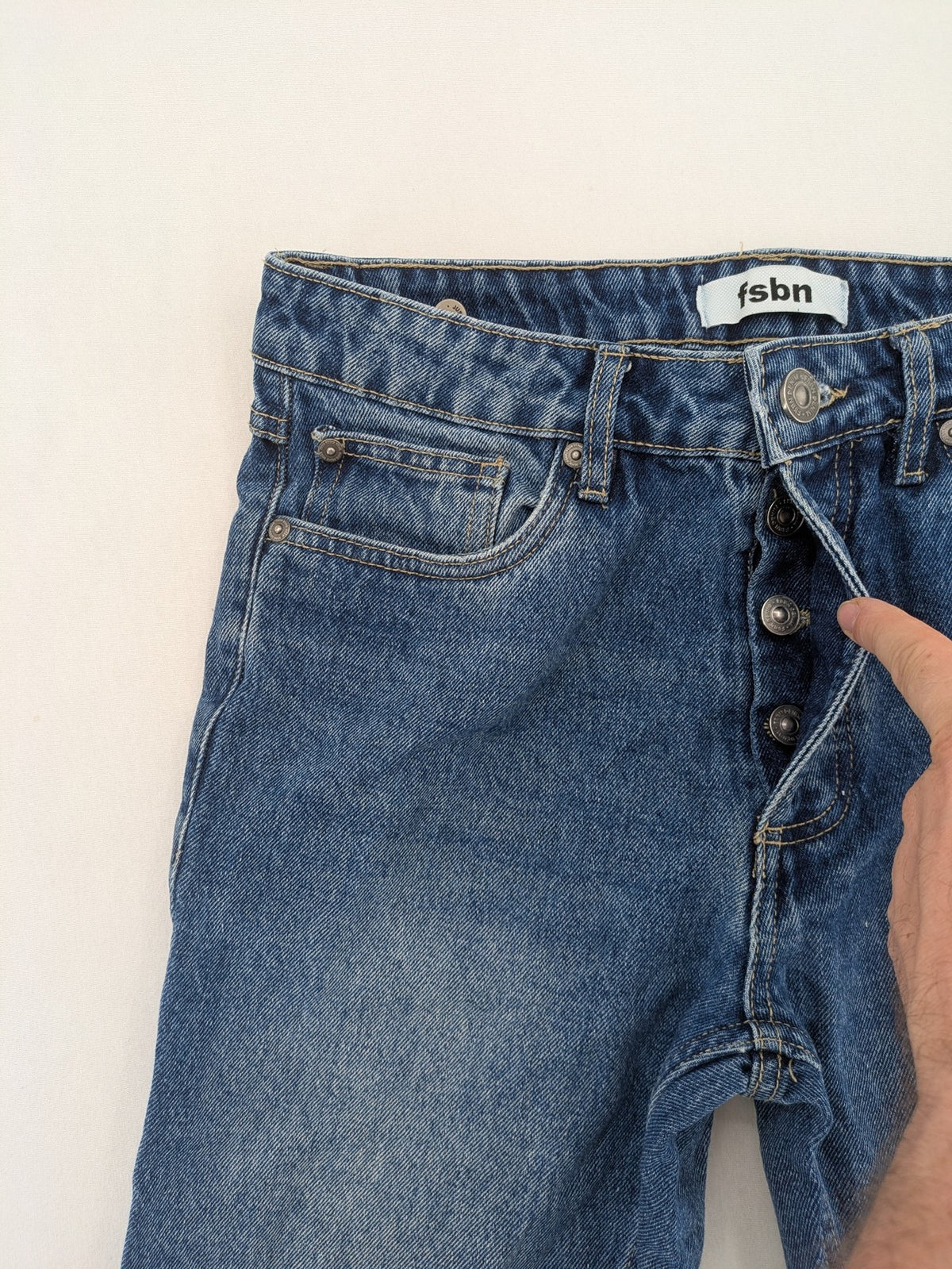 FSBN blue straight jeans with distressed knee rips and classic button fly.