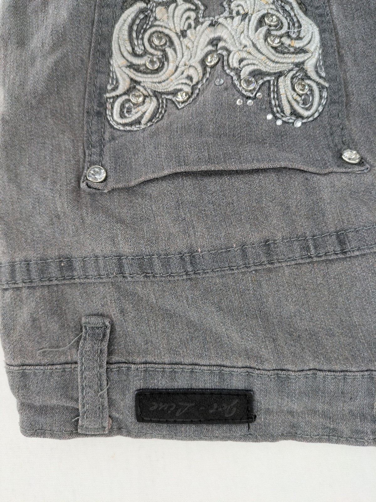 Jet Line grey straight jeans with embellished back pockets and frayed hem details.