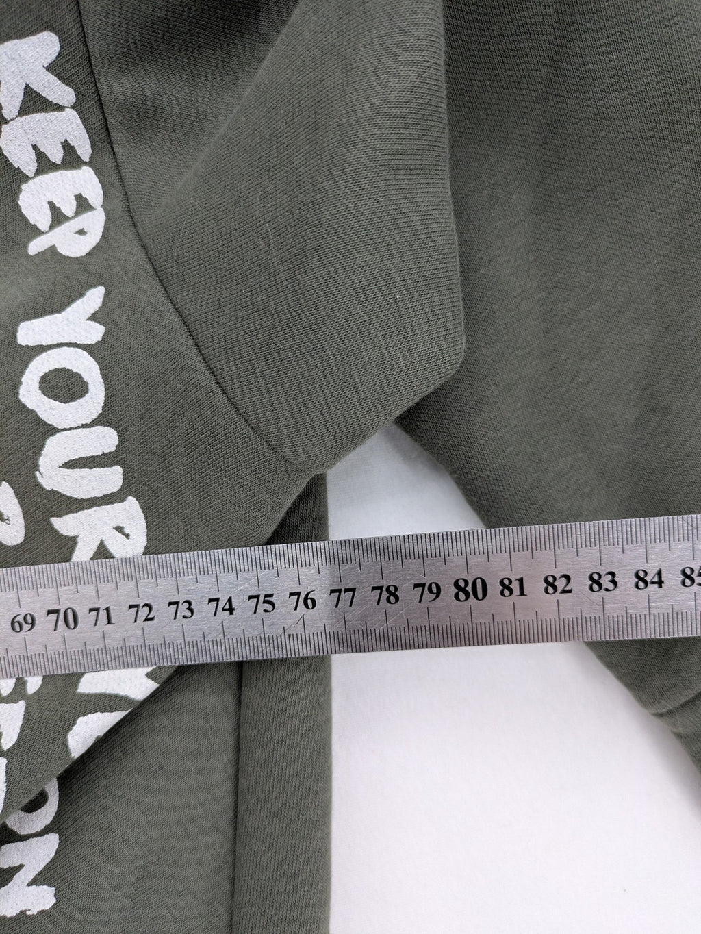 DCJ cream and olive green hoodie with cable knit pattern and graphic text sleeves.