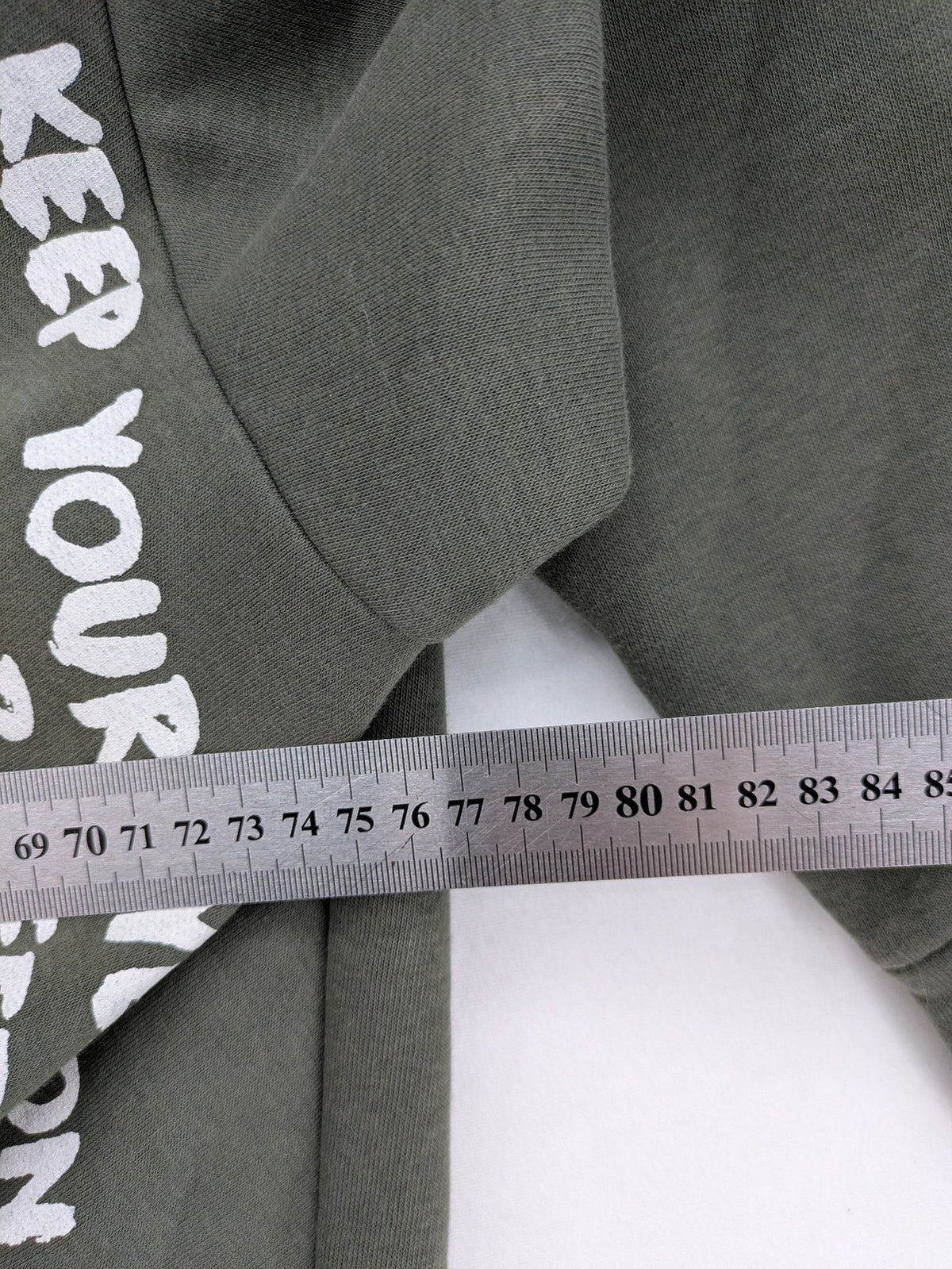 DCJ cream and olive green hoodie with cable knit pattern and graphic text sleeves.