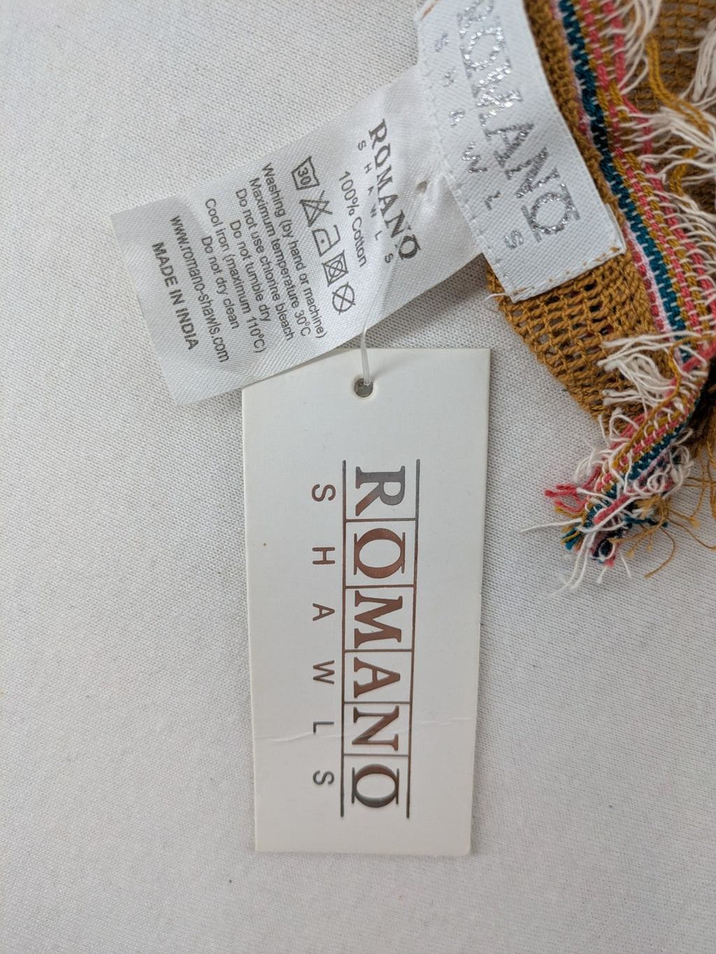 Romano multi scarf ocker with multicolored striped border and fringed edges.