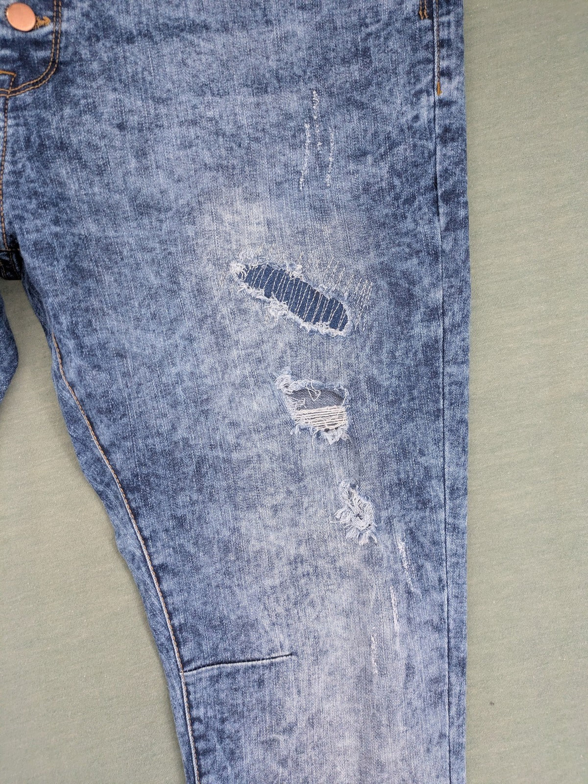 Janina blue slim fit jeans with acid wash, destroyed details, and button fly.