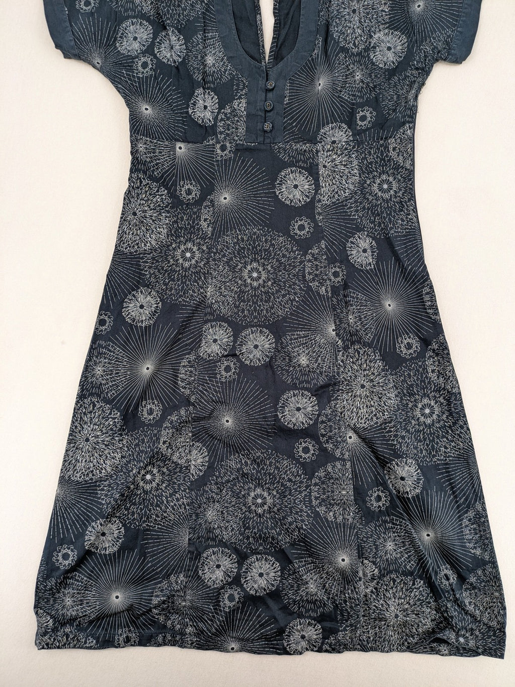 Muster navy dress with white abstract dandelion print, V-neck and collar details.