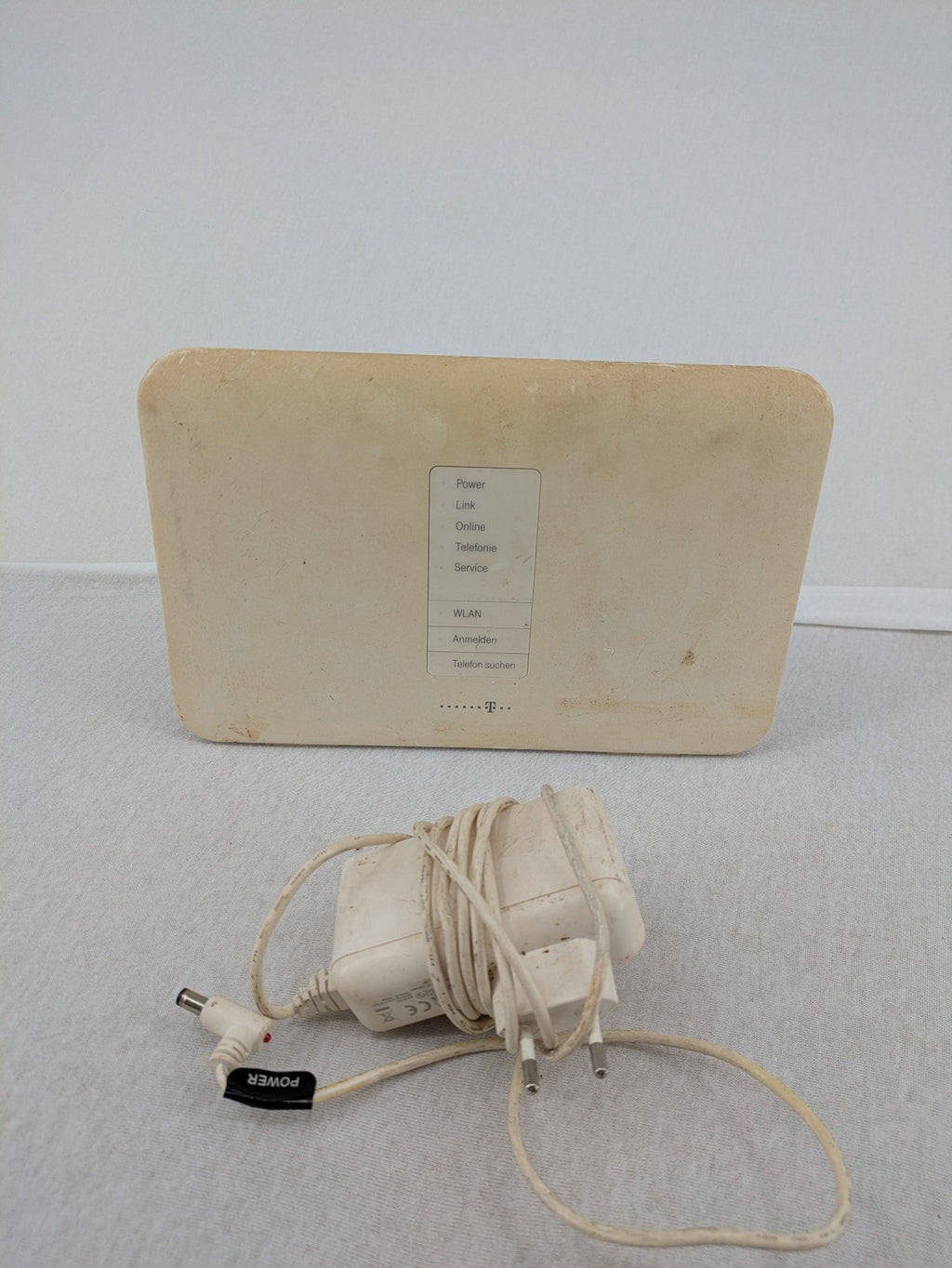 Deutsche Telekom beige wireless router with multiple LAN and VoIP ports.